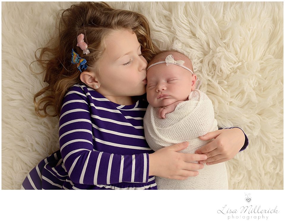 sibling kisses newborn baby sisters