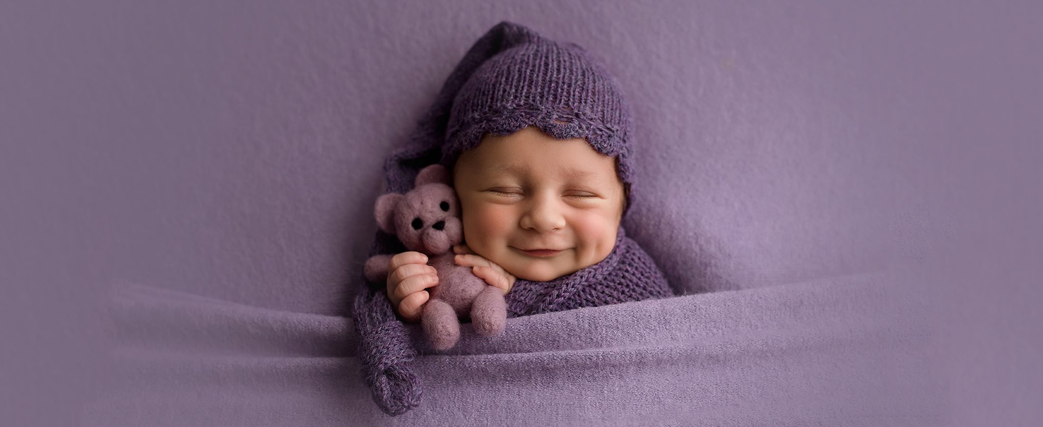 smiles newborn baby girl purple bear